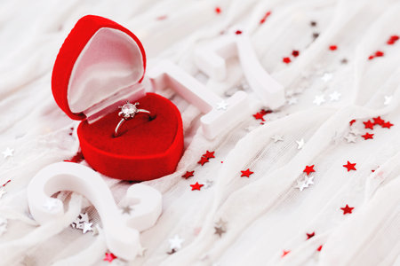 New Year 2017 on white fabric background with engagement diamond ring in red gift box. Good for...