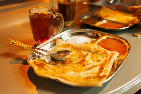 Chapati roti, Indian whole wheat flat bread, with spicy sauce and tea.の写真素材