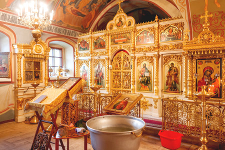 Golden religious utensils - Bible, cross, prayer book, missal, baptismal font. Interoior of Orthodox Christian Church. Russia.のeditorial素材