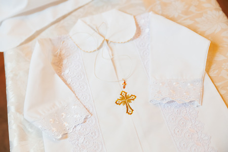 Laced dress for christening. Elegant outfit for little baby. Russian Orthodox church ceremony details.の写真素材