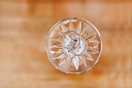 Pair of golden wedding rings on turned upside down glass. Symbol of love and marriage.の写真素材