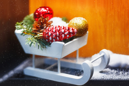 Christmas and New Year decorations - white wooden sledge with bright sparkling balls and fir tree branches.の写真素材
