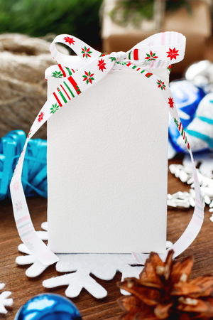 Christmas and New year background with presents, ribbons, balls and different blue decorations on wooden background. White present with ribbon and clear surface for your text. Mock up.の写真素材