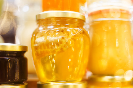Holiday fair. Jars of honey glowing in garlands of lighting bulbs.の写真素材