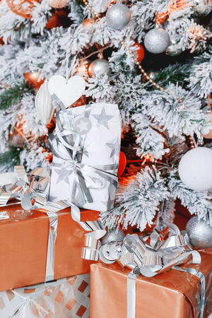 Christmas and New Year background with presents under the Eve Tree. Holiday winter background. Many gifts wrapped in golden and silver paper with bows.の写真素材