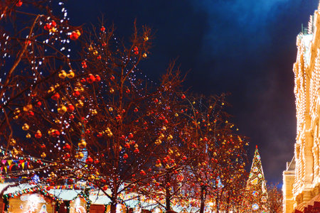 MOSCOW, RUSSIA - January 10, 2017. Streets of Moscow decorated for New Year and Christmas celebration. Tree with bright red and yellow balls. GUM (Main Department Store) with light bulbs on background. Russia.のeditorial素材