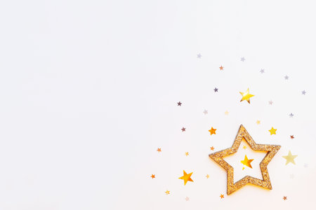 Christmas and New Year background with sparkling golden star and confetti. Holiday symbols on white...
