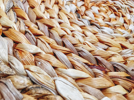 Close up photo of surface made of woven straw. Natural material for furniture and interior.の写真素材