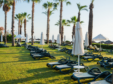 Early morning in hotel, typical for south-east part of Turkey. Sun loungers are on the lawn near sea. Kemer, Turkey.の写真素材