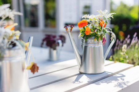 Tin garden watering can used as a vase for flowers. Funny garden design element.