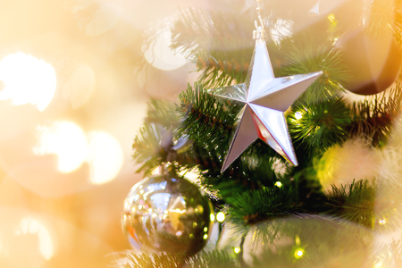 Fir tree decorated with shiny balls, star and light bulbs for Christmas and New Year celebration.の写真素材
