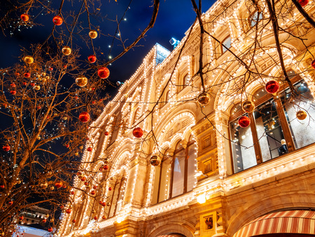 Streets of Moscow decorated for New Year and Christmas celebration. Tree with bright red and yellow balls. GUM (Main Department Store) building with light bulbs. Russia.の写真素材