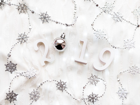 Christmas and New Year background with numbers 2019, silver decorations and light bulbs.の写真素材
