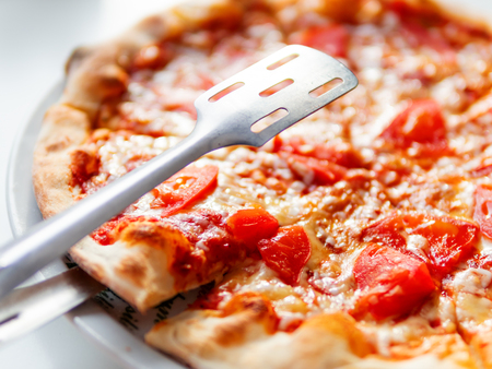 Pizza Margarita with baked ingredients - cheese with ham and tomatoes. Traditional italian cuisine.の写真素材