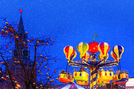 MOSCOW, RUSSIA - December 16, 2017.  Red Square decorated for New Year and Christmas fair. Spasskaya tower and colorful carousel decorated with light bulbs.のeditorial素材