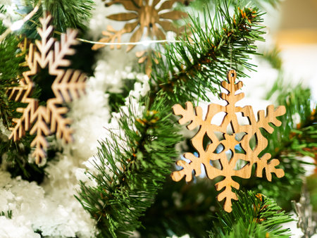 Christmas and New Year rustic decorations - wooden snowflakes on Christmas tree with light bulbs.の写真素材