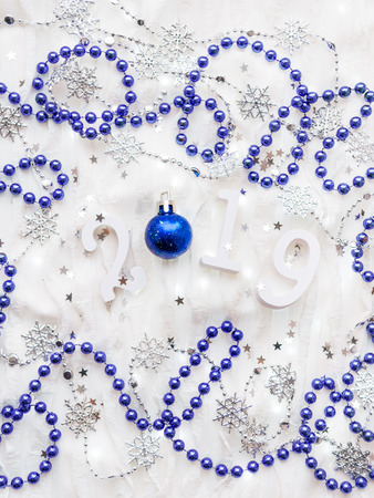 Christmas and New Year background with numbers 2019, silver and blue decorations and light bulbs.の写真素材