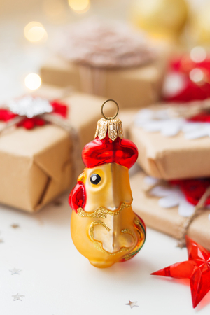 Christmas and New Year background with rooster, symbol of 2017 year, presents and decorations for Christmas tree. Holiday background with stars confetti and light bulbs. Place for text.の写真素材