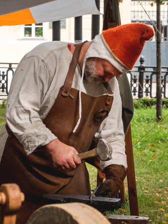 MOSCOW, RUSSIA - August 19, 2018. Man dressed as medieval blacksmith. Annual festival Times and Epochs. Historical reconstruction.のeditorial素材