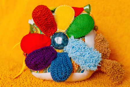 Colorful hand made toy for toddlers and babies. Busy cube. Soft  baby block made of fabric to develop skills and fine motor skills. Taggie Cube. Montessori busy toy.の写真素材