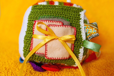 Colorful hand made toy for toddlers and babies. Busy cube. Soft  baby block made of fabric to develop skills and fine motor skills. Taggie Cube. Montessori busy toy.の写真素材