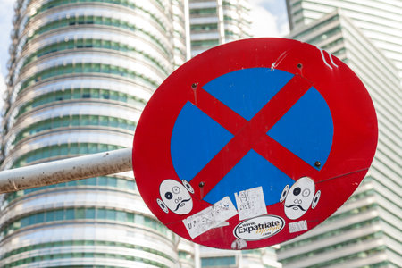 KUALA LUMPUR, MALAYSIA - February 01, 2013. Traffic parking ban sign with graffiti, stickers and advertizing.のeditorial素材