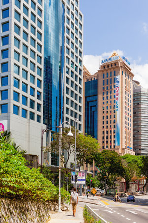 KUALA LUMPUR, MALAYSIA - February 01, 2013. man is walking pass skyscraper building of Affin Bank.のeditorial素材
