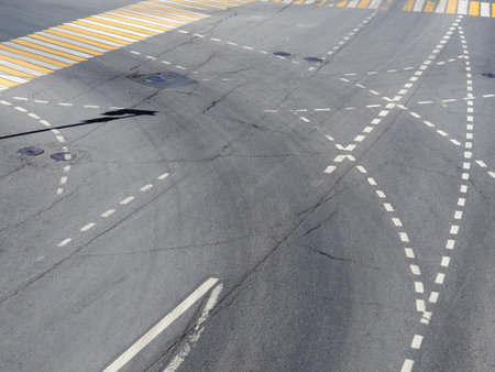 Road markings on the asphalt. Painted signs on the roadway and pedestrian crosswalk. Dotted line and...