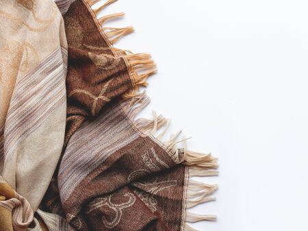 Beige and brown scarf on white background. Folded warm accessory with copy space.の写真素材