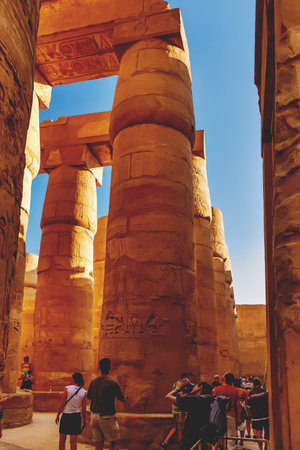 LUXOR, EGYPT - September 16, 2008. Tourists between columns in Karnak Temple Complex, famous...