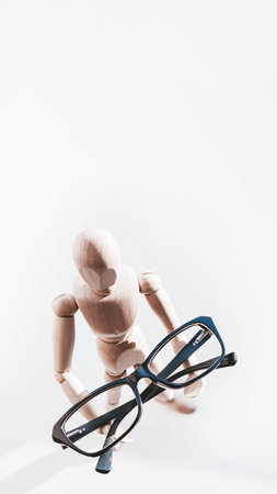 Wooden dummy with eyeglasses in hands. Mannequin presents glasses as a help for comfort life in case...