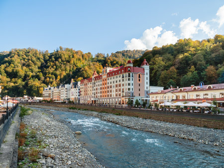 SOCHI, RUSSIA - October 13, 2018. Mzymta river embankment in Rosa Dolina. Famous Rosa Khutor Alpine Ski Resort near Sochi. Tourists walk near Mercure hotel.のeditorial素材