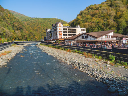 SOCHI, RUSSIA - October 13, 2018. Mzymta river embankment in Rosa Dolina. Famous Rosa Khutor Alpine Ski Resort near Sochi. Tourists walk near Tirol and Strela cable road stations.のeditorial素材