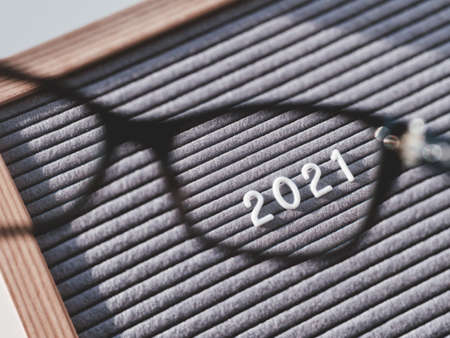 Top view on letterboard with numbers 2021 through eyeglasses. Flat lay concept of 2021 year results. 2021 review. Social, political or economical issue. Closer look on problems and achievements.の写真素材