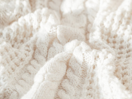 Hand made cable-knit sweater sweater. Texture of warm knitted fabric with pattern. White crumpled...