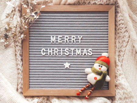 Letter board with season greeting Merry Christmas. Winter holiday spirit. Decorative snowman and shiny tinsel with stars.の写真素材