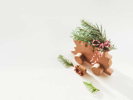 Two wooden trains with tied fir tree coniferous twigs. Dad and baby. Cute symbol of Christmas tree brought home for New Year celebration. Winter holiday spirit. Copy space.の写真素材