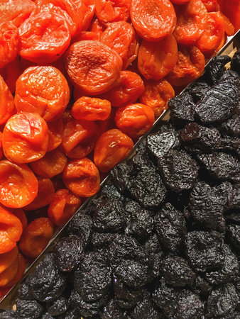 Boxes of dried apricots and prunes. Top view on dried fruits - tasty and healthy snack.