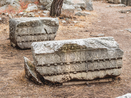 Ruins of ancient Phaselis city. Stones with carved ornaments at archeology site. Hadrian's gate of...