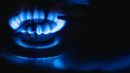 Blue flames of a gas in gas cooker. Fire on stove in dark. Banner with copy space.
