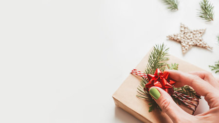 Christmas DIY presents wrapped in craft paper with fir tree branches and red bow. Decorations on New Year gifts. Festive background. Winter holiday spirit.の写真素材