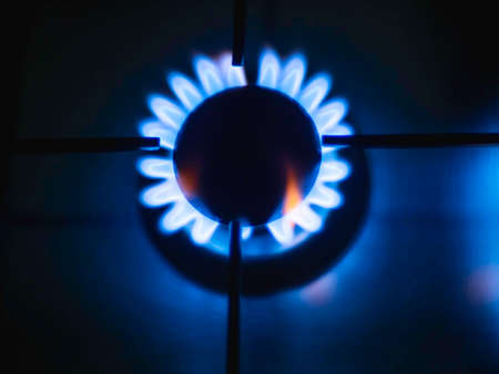 Blue flames of a gas in gas cooker. Top view on fire on stove in dark.の写真素材