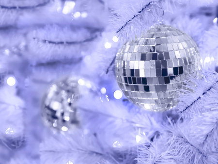 Very peri colored artificial Christmas tree with mirror disco balls. Bright purple fir tree...