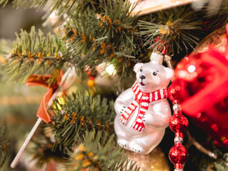Christmas tree with colorful outdoor decorations. Fir tree decorated with light bulbs and polar bear figure for New Year celebration.の写真素材