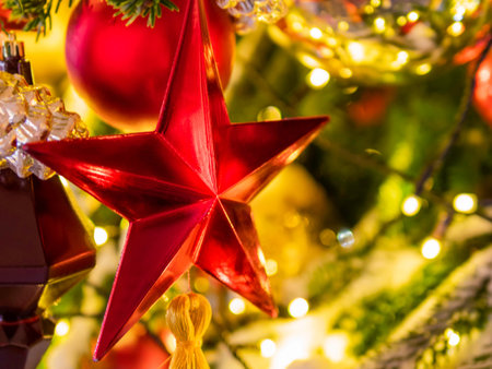 Christmas tree with colorful outdoor decorations. Fir tree decorated with light bulbs red stars for...