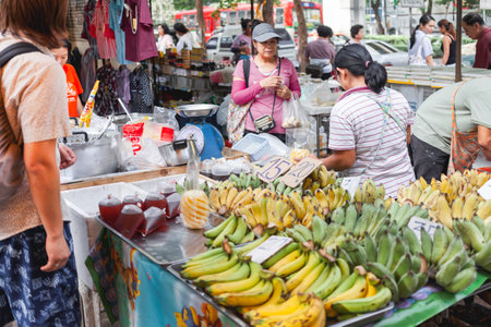 BANGKOK, THAILAND - October 23, 2012. Local people and tourists buy food on street market. Fruits and ready-to-eat soups and sauces in plastic bags.のeditorial素材