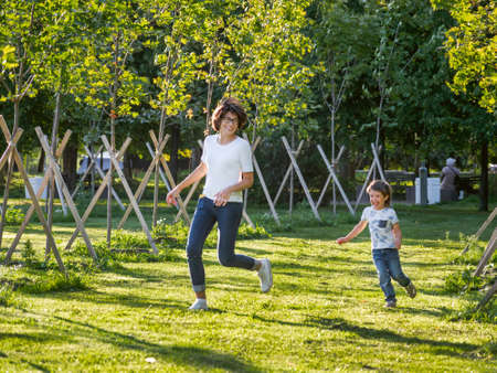 family life. Mother and son play in the park. summer vibes. Active outdoor game. lifestyle. Leisure activity open air.の写真素材