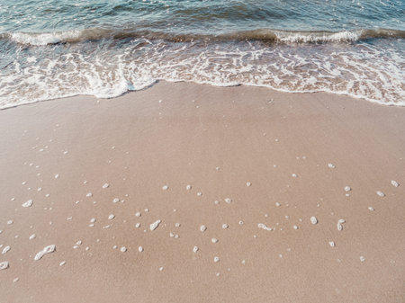 Sea coast with soft surf. sandy beach. Summer holidays on the seaside.