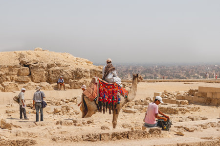 CAIRO, EGYPT - September 11, 2008. Local people near Egyptian pyramids. Different sellers offer tourists their goods and services.のeditorial素材