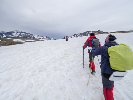 Tourists are hiking in snowy mountains. Sport and recreation at Kamchatka Peninsula, Russia. Active lifestyle outdoors.の写真素材